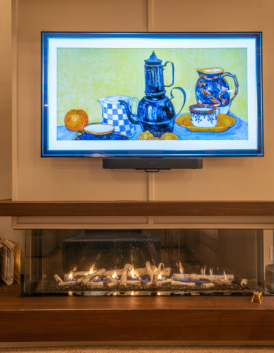 Teapot set painting over a lit fireplace